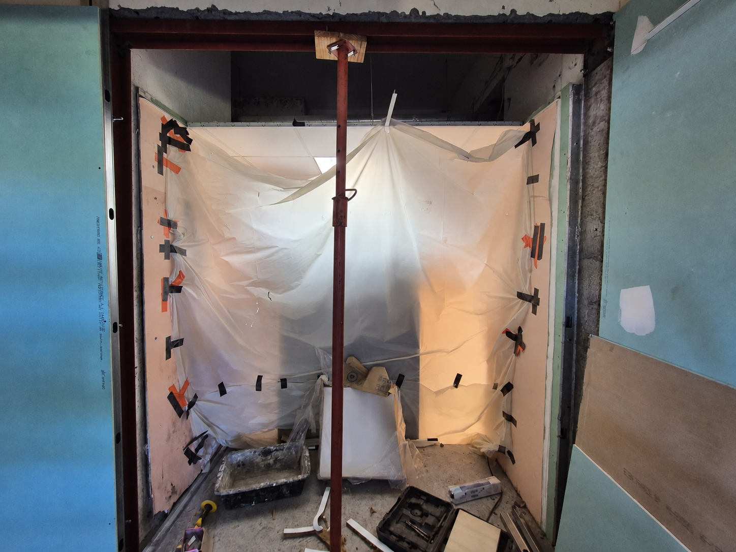 Ouverture en cours de travaux, avec un UPN en partie haute, un étai et une bâche de protection.